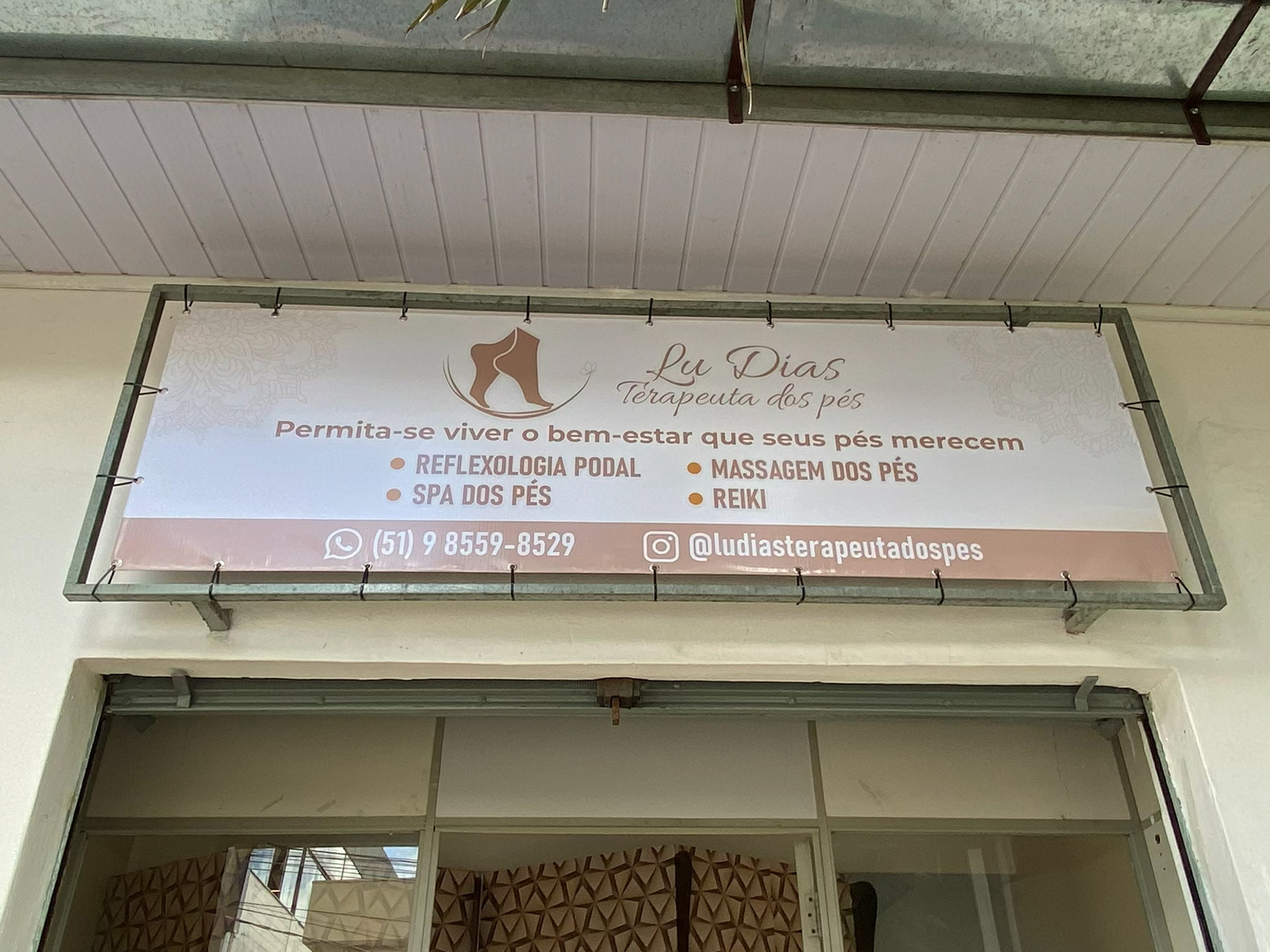 Placa de atendimento Lu Dias instalada acima da entrada